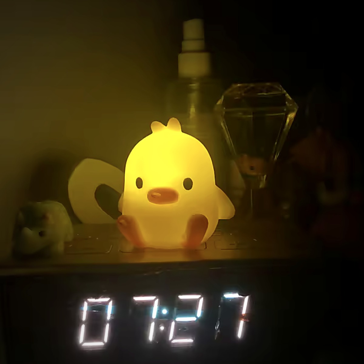 Duck Glow Buddy glowing beside a bedside clock